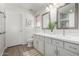 Bathroom with dual sinks, bright cabinets, mirrors and a view of the shower at 11520 W Lizard Ct, Surprise, AZ 85378