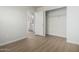 A clean and simple bedroom featuring an open closet and an ensuite bathroom at 11520 W Lizard Ct, Surprise, AZ 85378