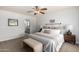 Bedroom with neutral color palette, ceiling fan, carpet and entrance to bathroom at 11520 W Lizard Ct, Surprise, AZ 85378