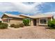 Inviting single-story home with desert landscaping, large windows and a walkway leading to the front door at 11520 W Lizard Ct, Surprise, AZ 85378