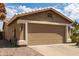 Spacious two-car garage featuring a neutral color door and well maintained desert landscaping around at 11520 W Lizard Ct, Surprise, AZ 85378