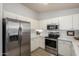 Bright kitchen featuring stainless steel appliances, white cabinets, and light countertops and flooring at 11520 W Lizard Ct, Surprise, AZ 85378