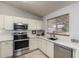 Well-lit kitchen featuring stainless steel appliances, white countertops, and ample cabinet space at 11520 W Lizard Ct, Surprise, AZ 85378