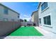 Enclosed backyard with paved patio, synthetic lawn, and outdoor cooking area at 12161 W Flanagan St, Avondale, AZ 85323