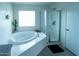 Bright bathroom featuring a soaking tub, glass-enclosed shower, and modern finishes at 12161 W Flanagan St, Avondale, AZ 85323