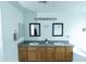 Bright bathroom featuring double sinks with wood cabinets, framed mirrors, and a soaking tub at 12161 W Flanagan St, Avondale, AZ 85323