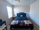 Bright bedroom featuring a black tufted headboard, bedside table, and natural light from the window at 12161 W Flanagan St, Avondale, AZ 85323