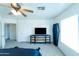 Bright bedroom featuring neutral walls, ceiling fan, dresser with a television, and natural light at 12161 W Flanagan St, Avondale, AZ 85323