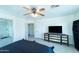 Bedroom featuring a black headboard bed, dresser, tv, carpet, and access to the bathroom at 12161 W Flanagan St, Avondale, AZ 85323
