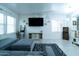 Bright living room featuring a gray sectional, modern decor, and entertainment center under a large TV at 12161 W Flanagan St, Avondale, AZ 85323