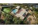 Expansive property with a pool, tennis court, and modern architecture surrounded by mature trees and landscaping at 13202 N 76Th Pl, Scottsdale, AZ 85260