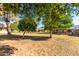 Lush backyard with mature trees, grassy area, and views of the home's exterior at 13823 N 99Th Dr, Sun City, AZ 85351
