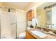 Bathroom with a tiled shower, granite vanity, and built-in cabinet for storage at 13823 N 99Th Dr, Sun City, AZ 85351