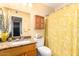 Bright bathroom featuring a granite countertop, wooden cabinet, and a yellow floral shower curtain at 13823 N 99Th Dr, Sun City, AZ 85351