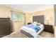 Comfortable bedroom with a tufted headboard, soft carpet, and natural light from the window at 13823 N 99Th Dr, Sun City, AZ 85351