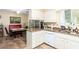 Open kitchen design with granite countertops, white cabinetry, and view to breakfast nook at 13823 N 99Th Dr, Sun City, AZ 85351