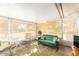 Bright sunroom with neutral decor, a teal glider bench, and views of the backyard at 13823 N 99Th Dr, Sun City, AZ 85351