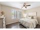 Comfortable bedroom with a ceiling fan, hardwood floors, and natural light from the windows at 14401 N Boxwood Ln, Fountain Hills, AZ 85268