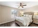 Inviting bedroom with ceiling fan, bedside tables and lamps, and a large window offering street views at 14401 N Boxwood Ln, Fountain Hills, AZ 85268