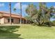 Charming home featuring a lush lawn, mature trees, and a classic tiled roof under a bright blue sky at 14401 N Boxwood Ln, Fountain Hills, AZ 85268