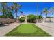 Backyard putting green with lush landscaping, palm trees, and a serene atmosphere, creating a golfer's paradise at 14430 W Windsor Ave, Goodyear, AZ 85395