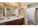 Bathroom features a double sink vanity with updated fixtures, a large mirror, and a separate toilet and shower area at 14430 W Windsor Ave, Goodyear, AZ 85395