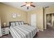 Bedroom with ceiling fan, neutral walls and carpet; features a comfortable queen-size bed with stylish bedding at 14430 W Windsor Ave, Goodyear, AZ 85395