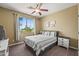 Bright bedroom with a large window, ceiling fan, neutral walls, and cozy carpet, creating a serene retreat at 14430 W Windsor Ave, Goodyear, AZ 85395