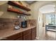 Charming coffee bar area with custom shelving, counter space, and tile backsplash at 14430 W Windsor Ave, Goodyear, AZ 85395