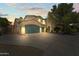 Home featuring a three-car garage, and desert landscaping at 14430 W Windsor Ave, Goodyear, AZ 85395