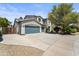 Charming home featuring a three-car garage, driveway, and desert landscaping at 14430 W Windsor Ave, Goodyear, AZ 85395