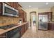 Modern kitchen featuring stainless steel appliances and classic brown cabinets at 14430 W Windsor Ave, Goodyear, AZ 85395