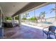 Covered patio overlooking the backyard, complete with a pool, putting green, and serene landscaping for outdoor enjoyment at 14430 W Windsor Ave, Goodyear, AZ 85395