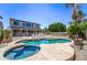 Beautiful backyard with a large swimming pool, spa, patio area, and lush landscaping, creating a private retreat at 14430 W Windsor Ave, Goodyear, AZ 85395