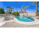Backyard oasis with a sparkling pool, spa, lounge chairs, and lush landscaping for ultimate relaxation and enjoyment at 14430 W Windsor Ave, Goodyear, AZ 85395