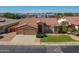 An aerial of a single-story home with a terracotta roof, three-car garage, and lush green landscaping at 1506 W Laurel Ave, Gilbert, AZ 85233