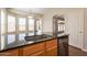 Close up of granite counters and modern kitchen faucet, with view to Gathering room beyond at 1506 W Laurel Ave, Gilbert, AZ 85233