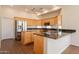 Spacious kitchen featuring granite countertops, a stainless steel refrigerator, and ample wood cabinetry at 1506 W Laurel Ave, Gilbert, AZ 85233