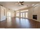 Bright, open living room with wood flooring, a ceiling fan, fireplace, and backyard access at 1506 W Laurel Ave, Gilbert, AZ 85233