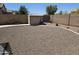 Large backyard featuring desert landscaping, block fence, and storage shed at 15352 W Ventura St, Surprise, AZ 85379
