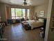 Large bedroom with tile floors, ceiling fan, and a big window with window coverings at 15352 W Ventura St, Surprise, AZ 85379