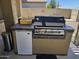 Outdoor built-in grill with stainless steel finish, stone counter, and mini fridge is perfect for entertaining at 15352 W Ventura St, Surprise, AZ 85379