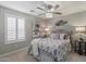This is a cozy bedroom with a ceiling fan, shuttered windows, and comfortable decorative touches at 16636 S 22Nd St, Phoenix, AZ 85048