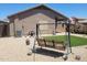 Cozy backyard with a charming swing, artificial turf, and easy-care gravel landscaping at 1769 E Jacob St, San Tan Valley, AZ 85140