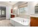 Bright bathroom with soaking tub, neutral walls, and vanity area at 18359 W Sweet Acacia Dr, Goodyear, AZ 85338