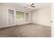 Bedroom featuring carpet flooring, ceiling fan, natural light, and an exterior door at 18359 W Sweet Acacia Dr, Goodyear, AZ 85338