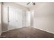 A carpeted bedroom with a sliding door closet and a fan at 18359 W Sweet Acacia Dr, Goodyear, AZ 85338