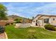 Backyard with lush lawn, desert landscaping, and view of the mountains at 18415 W Capistrano Ave, Goodyear, AZ 85338