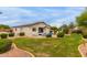 Spacious backyard showcasing a pristine pool, manicured lawn, and desert landscaping at 18415 W Capistrano Ave, Goodyear, AZ 85338