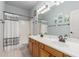 Bathroom featuring double sinks, shower-tub combo, and decorative wall art at 18415 W Capistrano Ave, Goodyear, AZ 85338